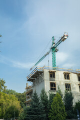 A tall crane stands by a building under construction.