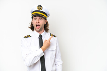 handsome Airplane pilot isolated on white background surprised and pointing side