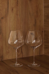 Two large empty wine glasses on a wooden kitchen surface. Modern kitchen interior style.