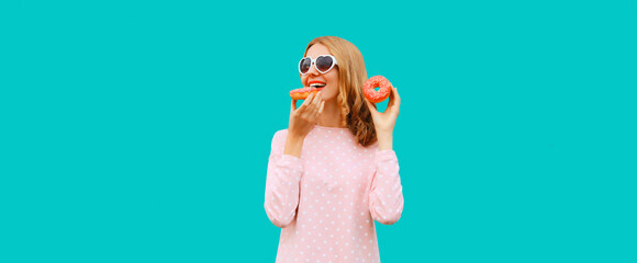 Portrait of happy cheerful laughing young woman with sweet donut having fun wearing heart shaped...