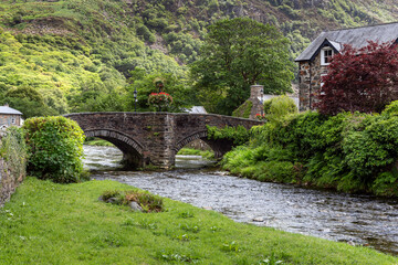 Fototapeta na wymiar The bridge over the River Colwyn in the picturesque village of Beddgelert in the Snowdonia National Park, North Wales.