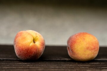 Fototapeta na wymiar Closeup of two peaches on the wooden surface.
