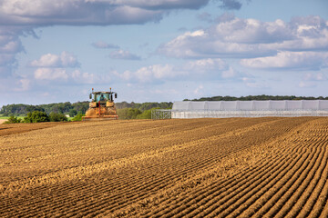 Fototapeta premium Tracteur au travail dans les champs au printemps.