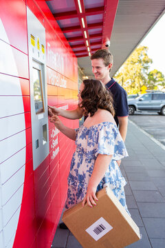 Young person with a disability using post office lock box in town