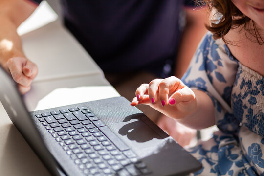 Girl with a disability using laptop technology to learn with one on one help