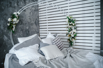 Large bed decorated with artificial flowers. High quality photo