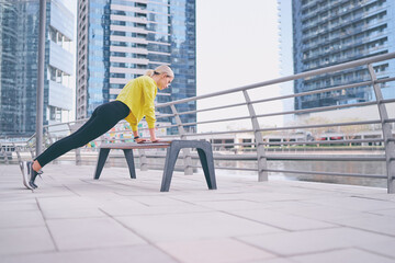 Healthy lifestyle. Young  woman exercising on city embankment.