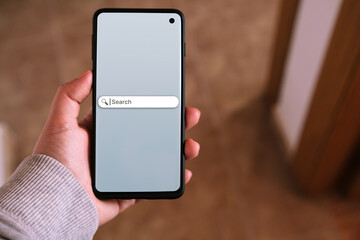 Woman using smartphone with search bar on screen. Search Engine Optimization SEO. Browser icon.