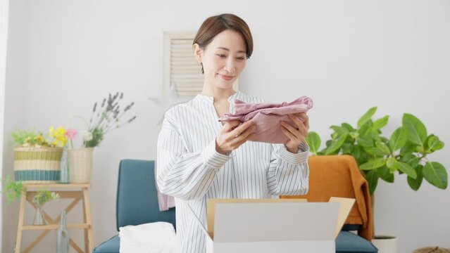 通信販売で衣類を売買する若い女性　ビジネスイメージ