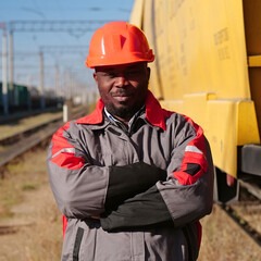 Railroad man in uniform and red hard hat look at the camera