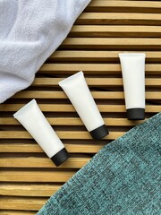 Cosmetic tube mockup with grooved wooden table background (flat lay)