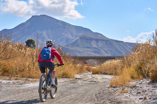 nice, active senior woman with her electric mountain bike on a trail tour in the dessert of Tabernas near Almeria, Andlusia, Spain