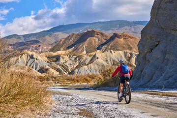 nice, active senior woman with her electric mountain bike on a trail tour in the dessert of Tabernas near Almeria, Andlusia, Spain