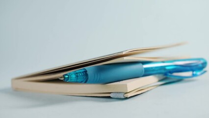 Closeup of a person putting down a sketchbook with a blue pen inside it