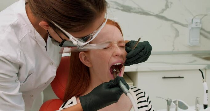 poor red-haired girl visiting dentist she is afraid of drilling Scared Redhead Female Patient Having Terrible Toothache pain