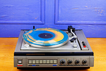 Obraz premium Vintage turntable vinyl record player with blue and orange vinyl