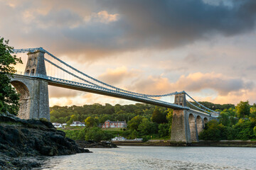 Sunrise at the Menai Suspension Bridge. Connecting the island of Anglesey with mainland Wales, the...