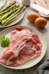 Bacon with fresh asparagus and eggs. Ingredients for cooking breakfast.