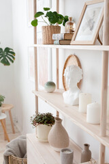 Retro modern decoration wall in the living room with pastel colors, white candles and shelf, modern vase, home plants in scandinavian interior close up
