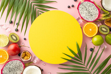 Tropical oasis. A beautiful top view flat lay of exotic fruits dragon fruit, kiwi, orange, lime, carambola, tomarillo and coconut on a pink background with palm leaves and a blank circle for text