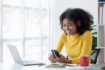 American woman relaxing in her room listening to music, she is a student studying online with laptop at home, university student studying online, online web education concept.