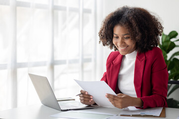 A young American woman is a start-up businesswoman, she sits in the office, managing and running a business from a young generation. Startup business management concept.