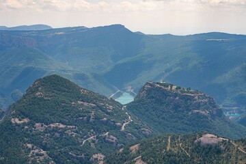 Aerial scenic view of the tree-covered mountain slopes and the river in a valley