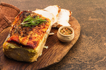 Baked pork loin with spices and herbs on vintage wooden cutting board. Ready to eat meat slices