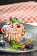 Freshly baked muffins with powdered sugar and fresh berries