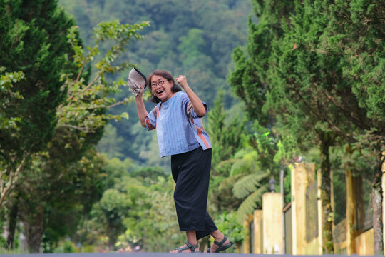 Middle-aged Asian woman walking in the morning around cool countryside