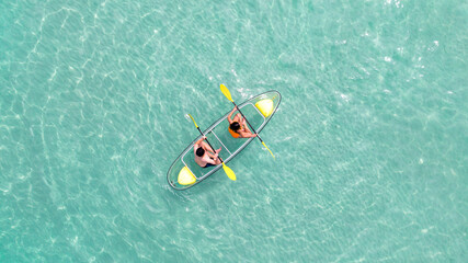 Asian couple travel Pataya by use kayak boat togather on on clean sea water - Powered by Adobe