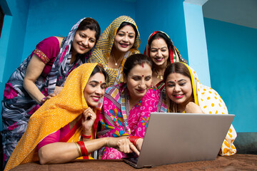 Group of rural  indian businesswomen wear sari learn  laptop,  gender equality, Career opportunities, Online job, Education, teaching computer, skill india. Social media .Entertainment. Inclusion 