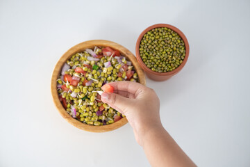Sprouting green gram bean Indian salad with Onion, coriander leaf , green chili and tomatoes. Indian sprouting gram bean salad kid eating and enjoying