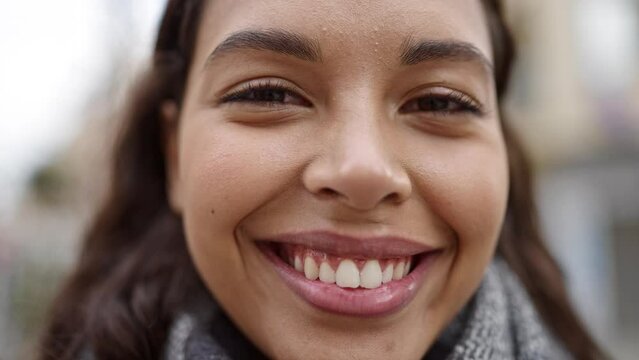 Young beautiful hispanic woman close up of eyes at street