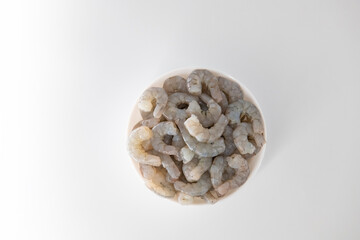 Fresh Raw shrimps cut and cleaned and kept it in a white bowl. Raw shrimps in white bowl and isolated in white background. Selective focused image...