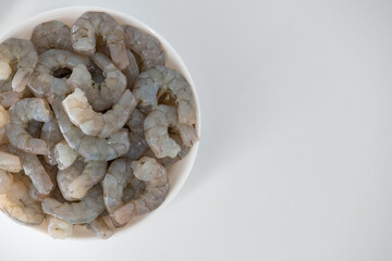Fresh Raw shrimps cut and cleaned and kept it in a white bowl. Raw shrimps in white bowl and isolated in white background. Selective focused image...