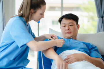 Obraz premium Female doctor having blood pressure test male at the clinic in the morning.