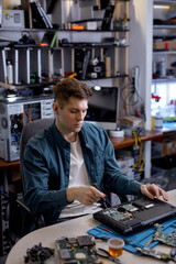 Professional engineer restores the laptop PC using various special tools. Electronic repair shop,...