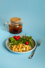 Fried scrambled eggs with spinach and tomatoes with tea on blue background