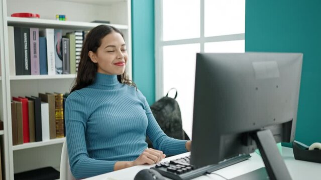 Young beautiful hispanic woman student using computer proud of herself for finishing work at university classroom
