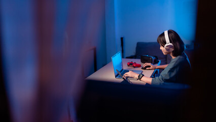 Little girl playing video game in the dark room