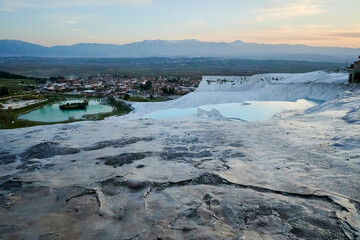 A scenic landscape of travertine pools in Pamukkale, Denizli, Turkey; a mineral formation caused by calcium-rich waters and recognized as UNESCO World Heritage.