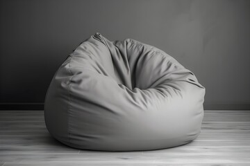 ..Soft grey bean bag lounges against a stark white background.