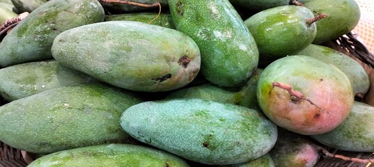 Organic mango fruit in the supermarket,closeup of photo.Fresh green mango on a market stall.