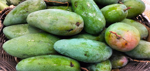 Organic mango fruit in the supermarket,closeup of photo.Fresh green mango on a market stall.