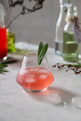 Refreshing summer rhubarb cocktail with sage, ice cubes and syrup.