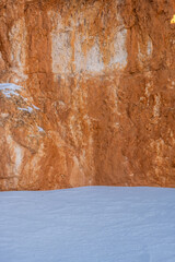 Snow Piled Up At The Base of Bright Orange Hoodoo