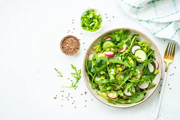 Fotobehang Green salad with spinach, arugula and radish with olive oil. Top view on white. © nadianb
