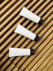 White cosmetic tube mockup with grooved wooden table background