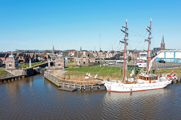 Aerial from the historical city Lemmer with an old traditional sailing ship in Friesland the...